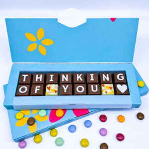 A box of solid milk and white chocolate blocks that spell out the words Thinking of you.