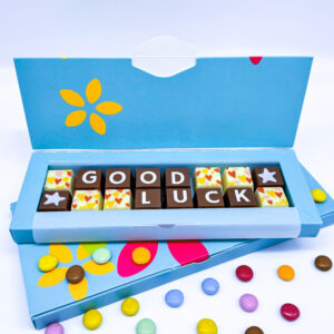 A box of solid milk and white chocolate blocks that spell out the message Good Luck.