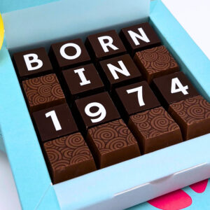 A square box of chocolates with born in 1974 on.