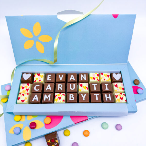 A box of personalised chocolates containing a welsh message.
