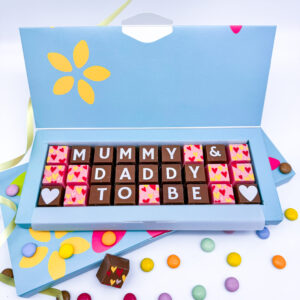 A box of personalised chocolates that read mum and dad to be.