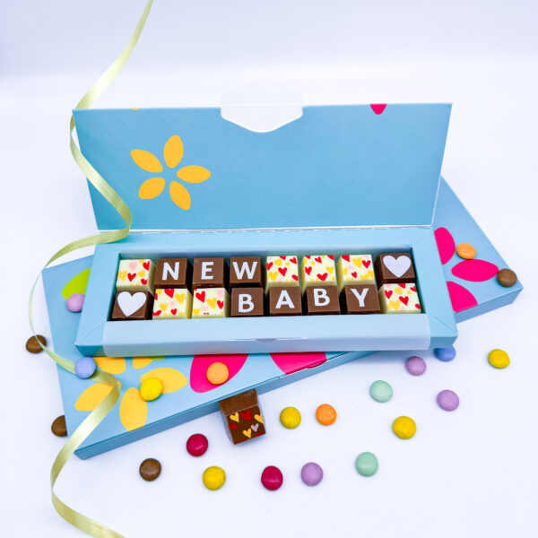 A box of solid milk and white chocolate blocks that spell out the message New baby.