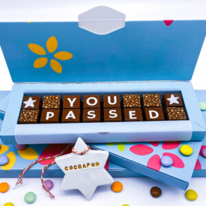 A box of solid milk chocolate with the message 'You Passed' spelled out and decorated with stars.