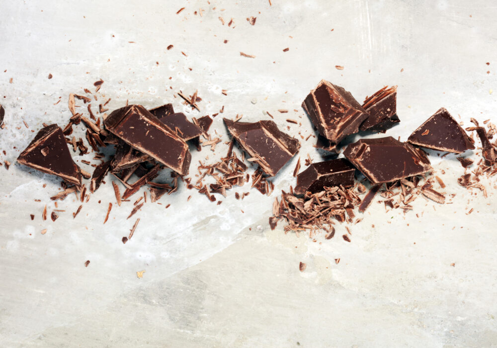 dark chocolate on stone table and broken pieces of cocoa
