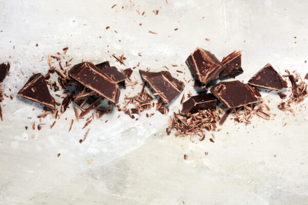 dark chocolate on stone table and broken pieces of cocoa